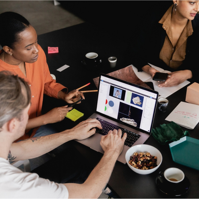 People working around a laptop